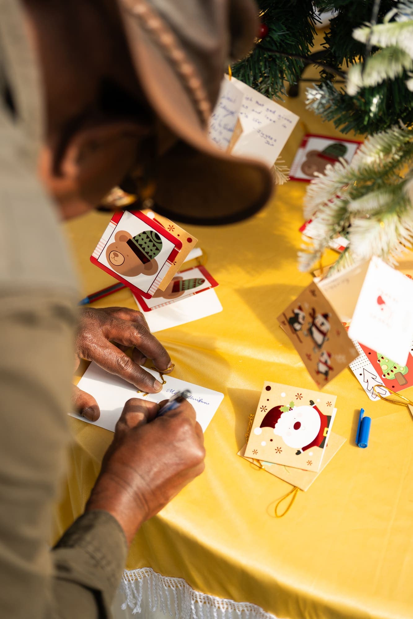 Hands writing a note at the card-making table