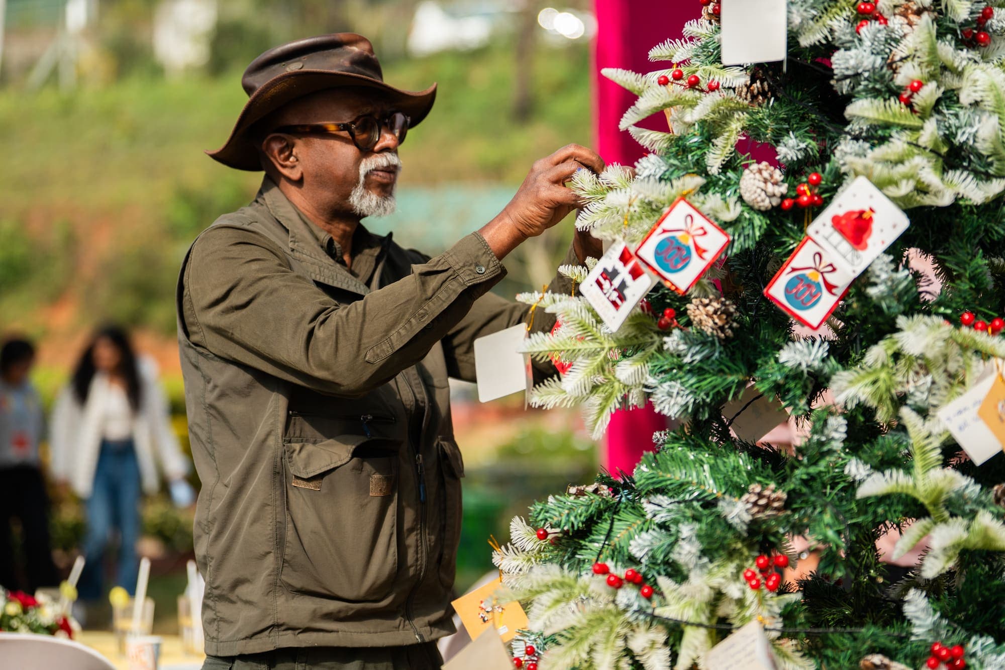 A visitor hanging a hand-made card on the tree