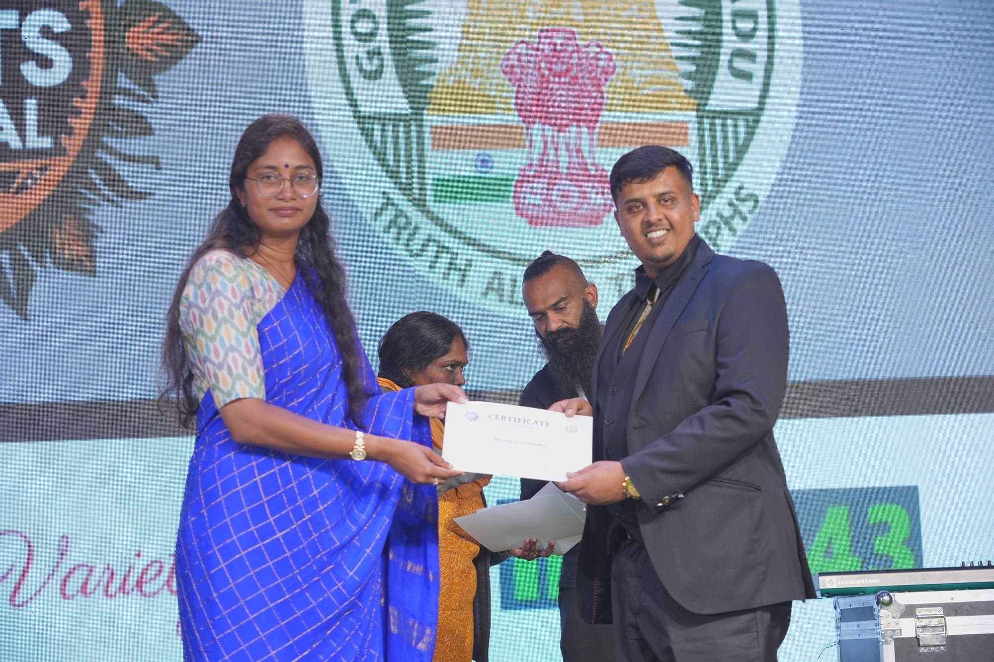 The Collector of the Nilgiris presenting a certificate to Events 43 on stage at the Roots Festival
